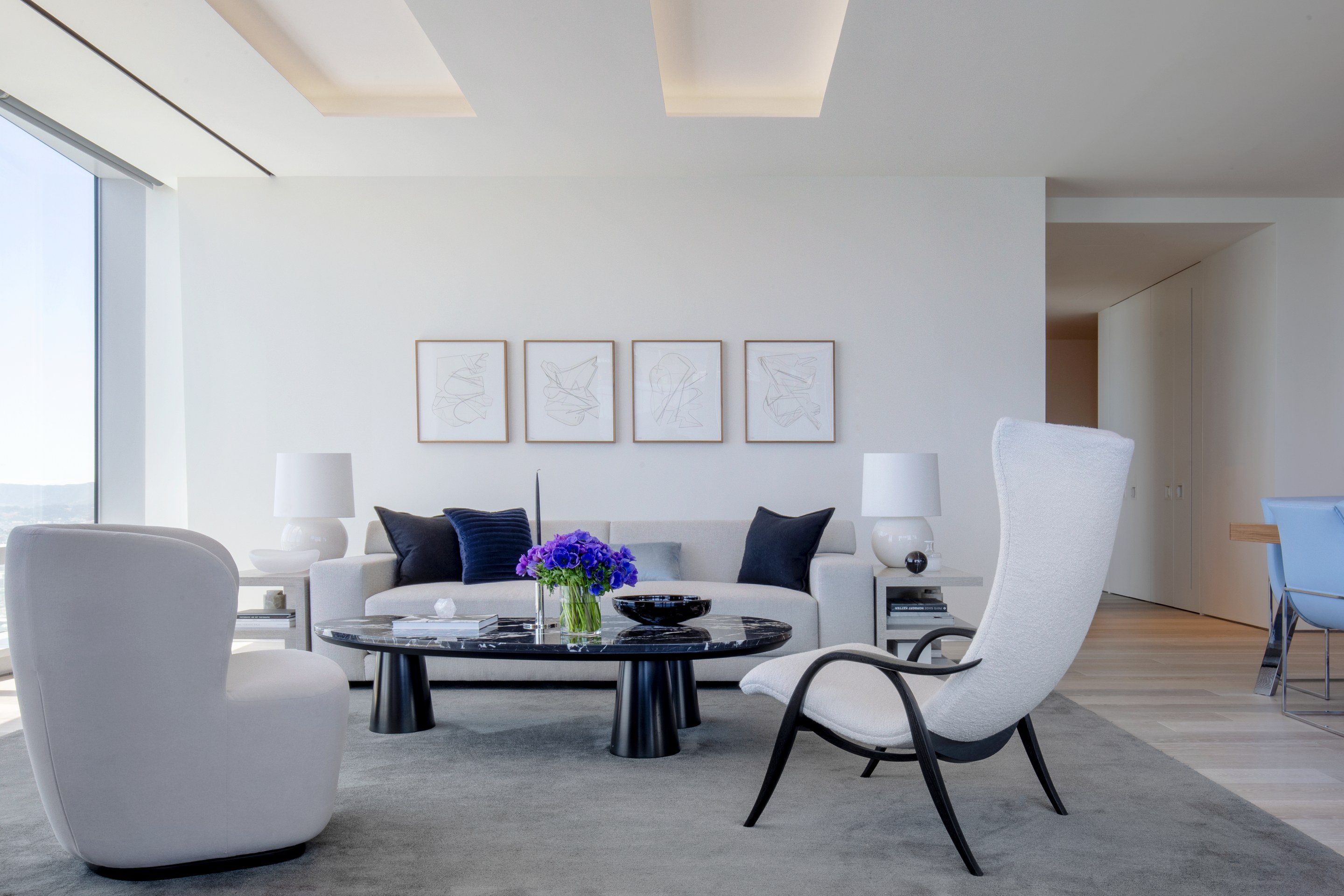 Cream upholstered seating beneath four framed drawings in the Short Shades interior